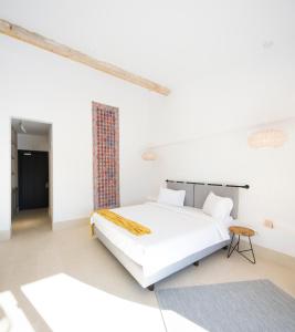 een witte slaapkamer met een bed en een tafel bij Hook Of Love - Le Mirage de la Mer in Olimp