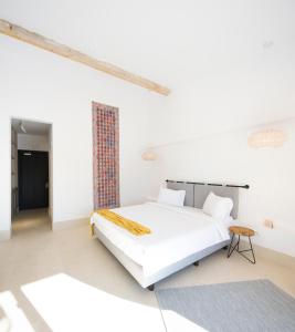 a white bedroom with a bed and a table at Hook Of Love - Le Mirage de la Mer in Olimp