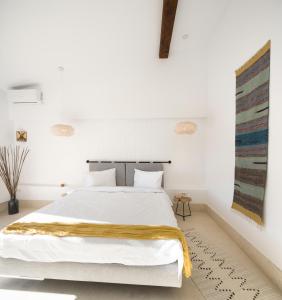 ein Schlafzimmer mit einem weißen Bett und einer gelben Decke darauf in der Unterkunft Hook Of Love - Le Mirage de la Mer in Olimp