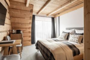 1 dormitorio con cama, escritorio y ventana en Willa Malinowa, en Zakopane