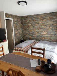 ein Schlafzimmer mit einem Bett mit Ziegelwand in der Unterkunft Le Skäli in Thollon