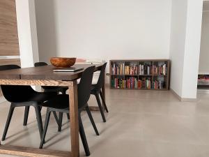 mesa de comedor con sillas negras y estante para libros en Newly Renovated-Holiday house with large garden en Galatina