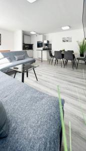 Schickes Apartment in City Lage B7 في كارلسروه: غرفة معيشة مع أريكة وطاولات وكراسي