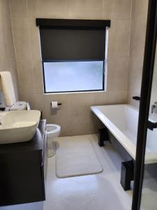a bathroom with a sink and a tub and a toilet at Manelo in Fourways in Fourways +50 photos