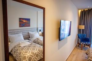 a mirror in a hotel room with a bed at Kavala Resort & Spa in Nea Karvali