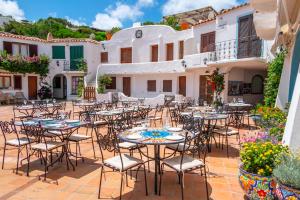 a patio with tables and chairs in front of a building at La Smeraldina Resort in Santa Teresa Gallura