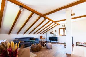 Elle comprend un salon doté de plafonds en bois et d'un canapé bleu. dans l'établissement Villa Vita, à Trilj
