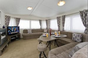 uma sala de estar com um sofá e uma mesa em L76 Rickardos Holiday Lets em Mablethorpe