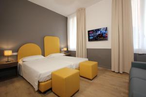 pokój hotelowy z łóżkiem i 2 żółtymi stołkami w obiekcie San Marco Gallery w Wenecji