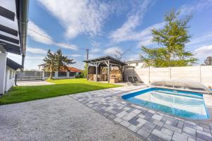 a backyard with a swimming pool and a house at Sóstó Pihenőház By BLTN in Siófok