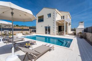 una foto di una villa con piscina di Villa Ora with Heated pool, Whirlpool, 4 bedrooms a Grohote