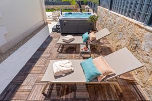 格罗霍特Villa Ora with Heated pool, Whirlpool, 4 bedrooms的庭院设有2张桌子和浴缸。