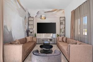 ein Wohnzimmer mit 2 Sofas und einem Flachbild-TV in der Unterkunft Villa Ora with Heated pool, Whirlpool, 4 bedrooms in Grohote
