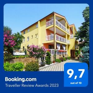 a yellow apartment building with flowers in front of it at Rooms Ivana in Međugorje