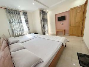 a bedroom with a large bed and a tv at Motel Phương Thảo Phong Tập Thể in Vung Tau