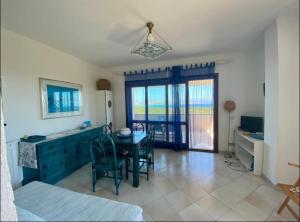 a living room with a table and chairs and a bedroom at Stintino casa panoramica a 500 mt dal mare IUN E8597 in Stintino