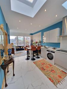 a kitchen with blue walls and a dining room with a table at flat Covent Garden in London