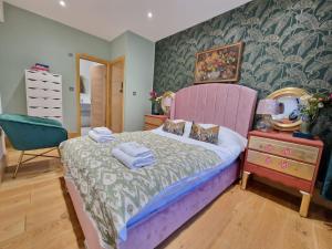 a bedroom with a large bed with a pink headboard at flat Covent Garden in London