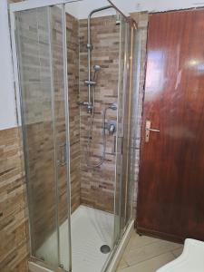 una doccia con porta in vetro in bagno di Villa Paola a Capaci