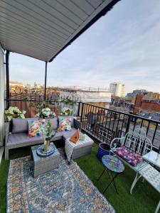 a patio with a couch and chairs on a balcony at flat Covent Garden in London