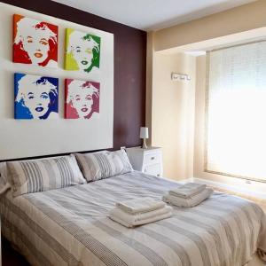 ein Schlafzimmer mit einem großen Bett mit drei Handtüchern darauf in der Unterkunft Piso Riazor 4 habitaciones in A Coruña