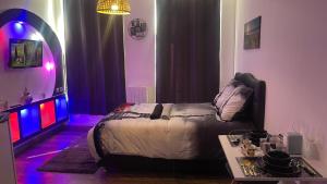 een slaapkamer met een bed, een tafel en een spiegel bij Le cocon du Nil jolie studio in Douai