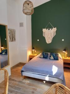 a bedroom with a bed and a green wall at Les chambres d'hôtes du Relais d'Aguilar in Tuchan