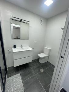 ein weißes Bad mit einem Waschbecken und einem WC in der Unterkunft Apartamento Luli in Calpe