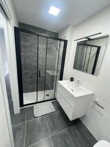 ein Badezimmer mit einem weißen Waschbecken und einer Dusche in der Unterkunft Apartamento Luli in Calpe