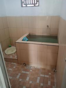 een kleine badkamer met een bad en een toilet bij Homestay Nova Klayar in Kalak