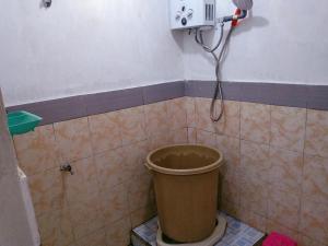 een badkamer met een vuilnisbak en een douche bij Homestay Nova Klayar in Kalak