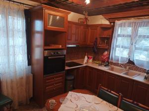 a kitchen with wooden cabinets and a table and a sink at Stelios house in Theológos