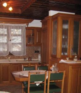 a kitchen with wooden cabinets and a table and chairs at Stelios house in Theologos