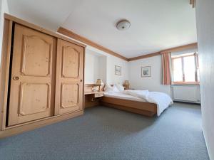 1 dormitorio con 1 cama y un gran armario de madera en Gasthof zum Gellnwirt en Tamsweg