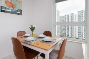 a dining room with a wooden table and chairs at Stadion Apartment with Parking by Renters in Gdańsk