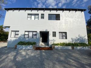 a white house with a driveway at The Baobab in Northriding