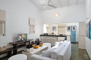 sala de estar con sillas blancas y cocina en Taru Villas 906 - Hikkaduwa en Hikkaduwa