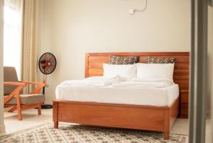 a bedroom with a wooden bed with white sheets at Chobwe Lodge in Chelston