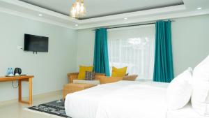 a bedroom with a white bed and blue curtains at Chobwe Lodge in Chelston