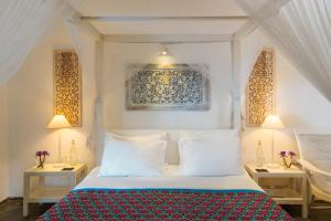 a bedroom with a bed with two tables and two lamps at Taru Villas 906 - Hikkaduwa in Hikkaduwa +47 photos