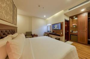 a hotel room with a large bed and a desk at Imperial Nha Trang in Nha Trang