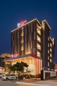 a hotel building with cars parked in front of it at Ramada Encore by Wyndham Siliguri Sevoke Road in Siliguri