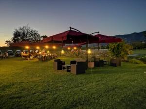 um grupo de mesas e guarda-chuvas num campo à noite em Agriturismo Calendiluna em Luni