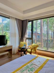 - une chambre avec un lit et une grande fenêtre dans l'établissement Mang Den Green Hotel, à Kon Tum