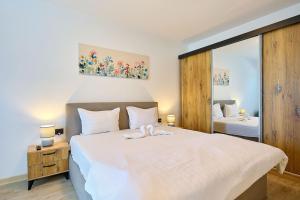 a bedroom with a large white bed and a mirror at MDApartment in Infinity Beach Resort- Parking in Mamaia +44 photos