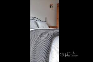 1 dormitorio con 1 cama con edredón blanco en Pintularrama - Casa Rural en Póo de Llanes en poo de Llanes