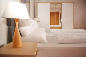 una lámpara sentada en una mesa junto a una cama en Hotel Sonnenhof - bed & breakfast & appartements, en Innsbruck