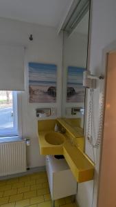 baño con lavabo amarillo y espejo en Naturhotel Forsthaus, en Annaberg-Buchholz
