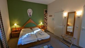 a bedroom with a large bed and a green wall at Naturhotel Forsthaus in Annaberg-Buchholz