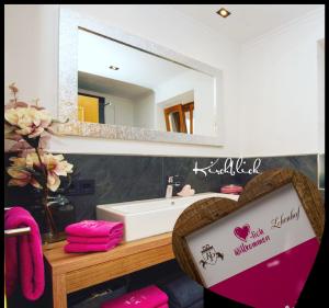 ein Bad mit einem Waschbecken und einem Spiegel in der Unterkunft Appartements Lehenhof in St. Johann im Pongau